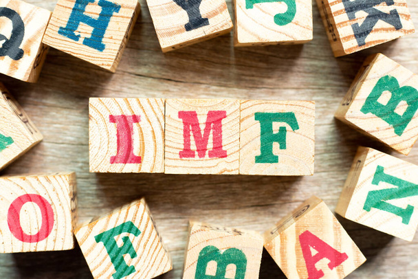 Alfabeto letra bloco em palavra FMI (abreviatura do Fundo Monetário Internacional) com outro sobre fundo de madeira - Foto, Imagem