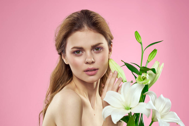 Красивая женщина с цветами на розовом фоне макияж модель - Фото, изображение