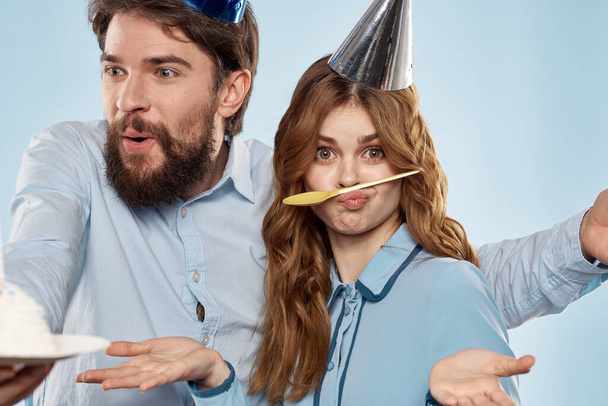 Fröhlich Mann und Frau mit Kuchen in einem Teller Corporate Party blauer Hintergrund - Foto, Bild
