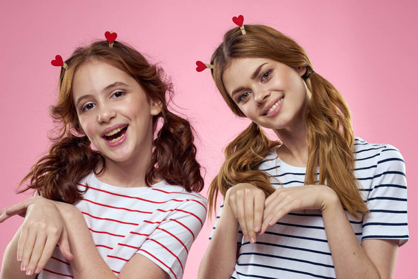 alegre chica y mujer en un fondo rosa hermanas familia emociones - Foto, imagen