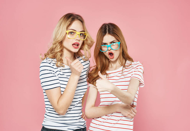 две девушки в полосатых футболках в очках моды забавный образ жизни изолированный фон - Фото, изображение