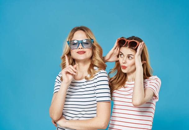 весёлые женщины в полосатых футболках в студии моды солнцезащитных очков - Фото, изображение