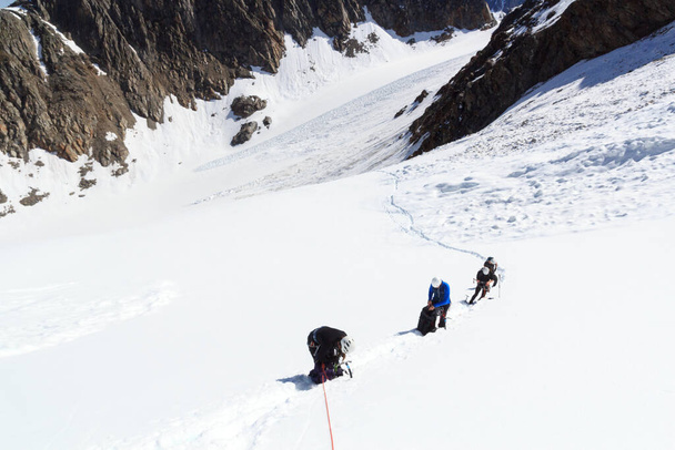Equipe de corda fazendo uma pausa no glaciar Sexegertenferner e panorama de neve de montanha com céu azul em Tyrol Alps, Áustria - Foto, Imagem