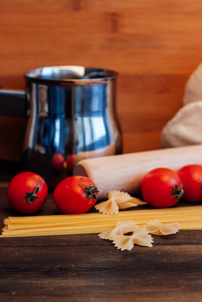 italská těstoviny těstoviny cherry rajčata vaření dřevěný stůl - Fotografie, Obrázek
