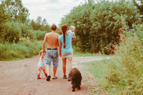 Сім'я йде по шляху, тримаючи руки посміхаючись
 - Фото, зображення