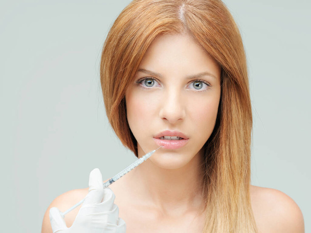 gyönyörű fiatal nő, akinek kolagén injekció ajkak - Fotó, kép
