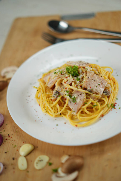 смачна спагетті карбонара, що подається на дерев'яному столі обідня вечеря
 - Фото, зображення