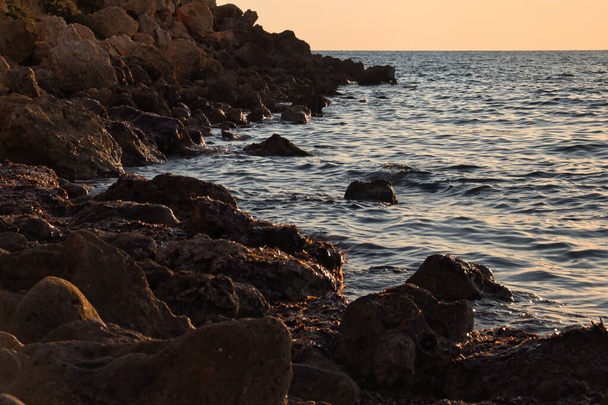 Rocas en una playa en Golden Bay al atardecer en Malta. - Foto, imagen