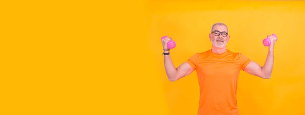 Portrait of senior man exercising with dumbbells - Foto, Imagen