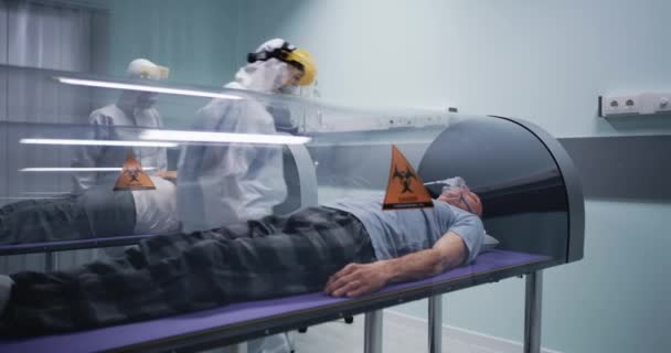 Lekarze sprawdzający starszych mężczyzn w komorach hiberbarycznych - Materiał filmowy, wideo