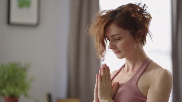 erwachsene friedliche Dame macht Atemübungen während des morgendlichen Trainings zu Hause, steht allein im Raum und meditiert - Filmmaterial, Video
