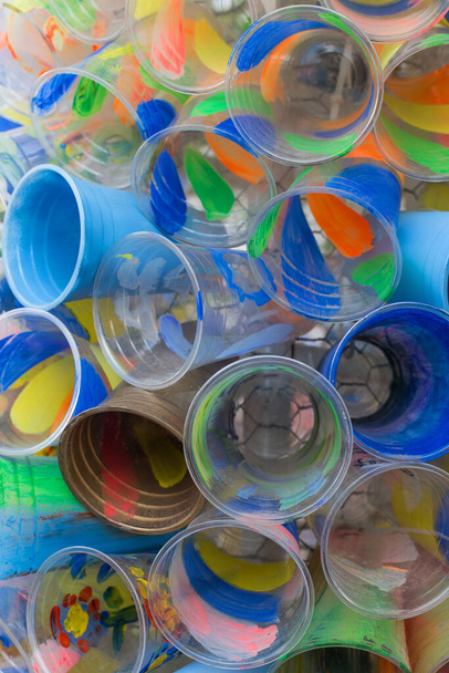 Χρωματιστά πλαστικά ποτήρια. Η έννοια της ανακύκλωσης πλαστικών και του περιβάλλοντος. Απορρίμματα πλαστικών - Φωτογραφία, εικόνα