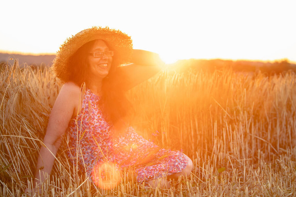 hermosa mujer madura en vestido de sol en el campo de trigo en el espacio de copia puesta del sol - Foto, imagen