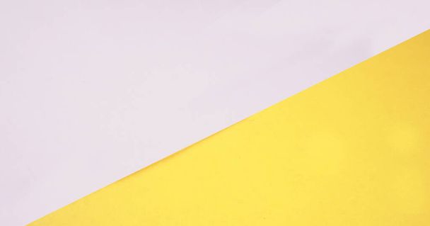 Yellow and white paper background. Concept of primary colors. Angle and diagonal lines. Top view flat lay with copy space. - Foto, Imagen