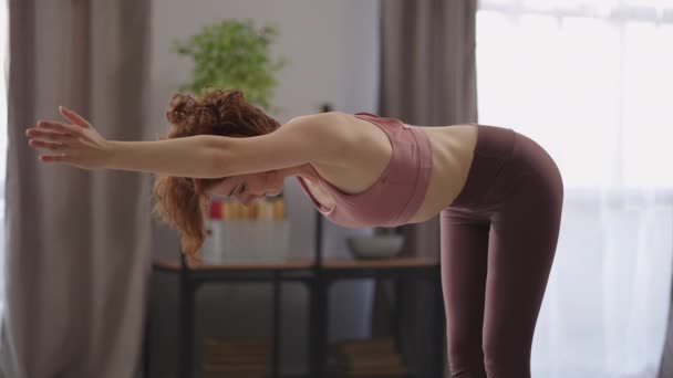 αθλητική κυρία κάνει σωματικές ασκήσεις στο διαμέρισμα, θέρμανση και τέντωμα του σώματος πριν από την εκπαίδευση, γυμναστήριο στο σπίτι, υγιεινό τρόπο ζωής - Πλάνα, βίντεο