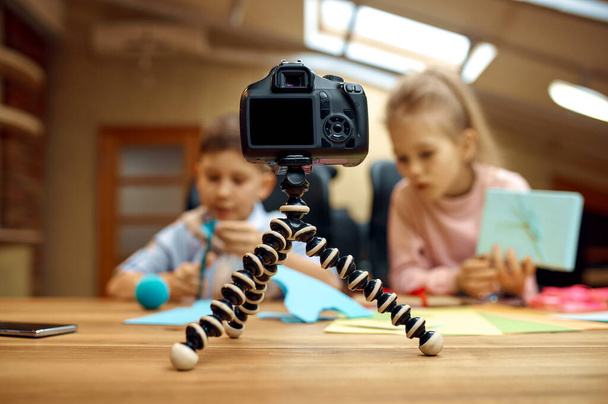 Παιδιά bloggers ποζάρουν στην κάμερα, μικροί bloggers. Παιδιά blogging σε στούντιο στο σπίτι, social media για νέους ακροατές, online internet broadcast - Φωτογραφία, εικόνα