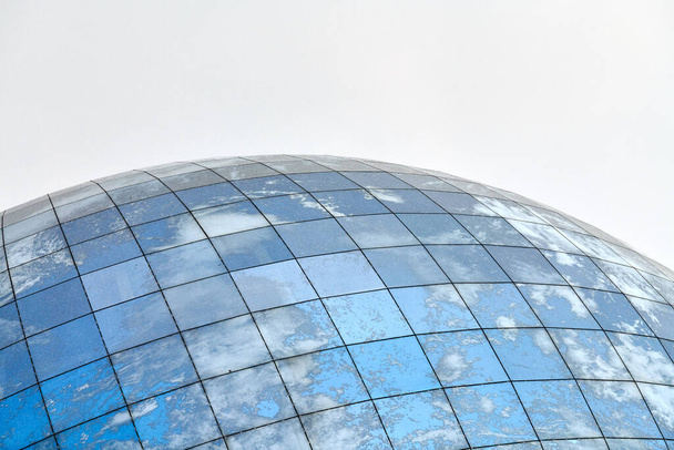Edificio moderno esférico de cristal con reflejo de cielo azul y nubes. Primer plano, espacio de copia, aislado. - Foto, imagen