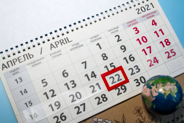 kalender op blauwe achtergrond, feestdag op aarde.Gemarkeerde datum 22 april - Foto, afbeelding