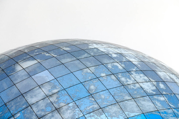 Bâtiment moderne sphérique en verre avec reflet du ciel bleu et des nuages. Gros plan, espace de copie, isolé. - Photo, image