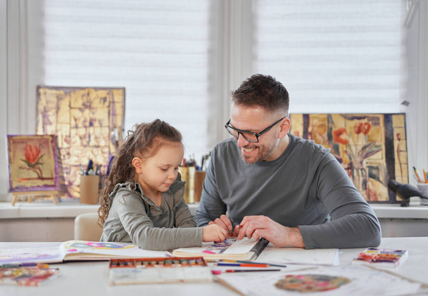 Тато і маленька дочка проводять малювання разом
 - Фото, зображення