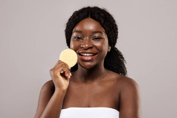 Koncept čištění kůže. Portrét krásné africké americké ženy držící kosmetickou houbu - Fotografie, Obrázek