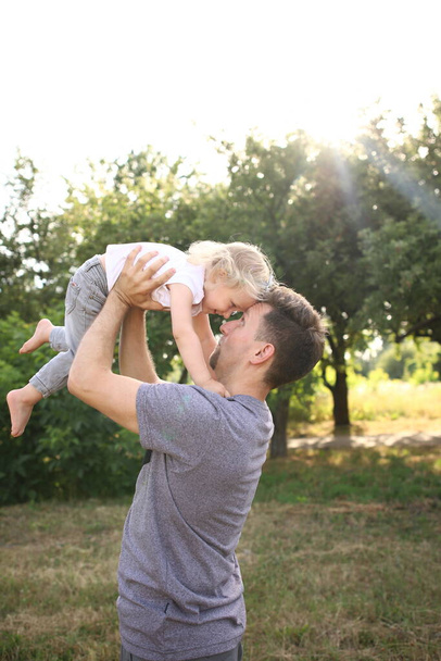 幸せな愛情の父と娘の演奏と抱擁。家族の散歩だ。夏時間一緒に、太陽の光。幸せな父の日. - 写真・画像