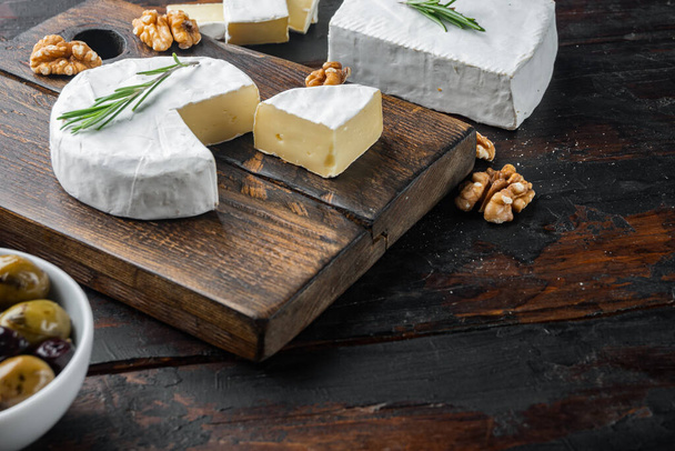Camembert francés suave de conjunto de queso normandía, sobre fondo de madera oscura con espacio de copia para texto - Foto, Imagen