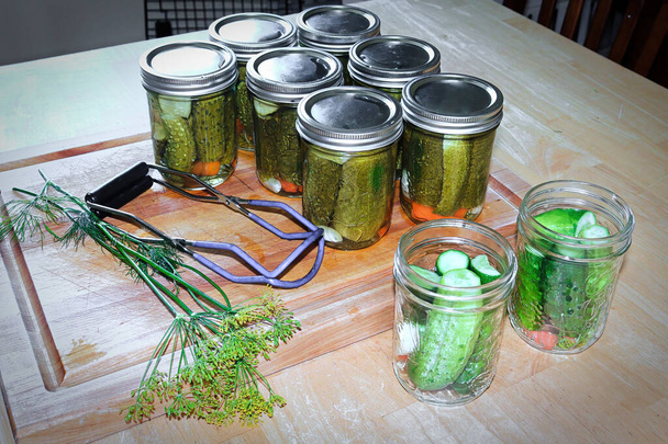 Vue de la table des bocaux de décapage pleins de concombres en conserve et frais - Photo, image