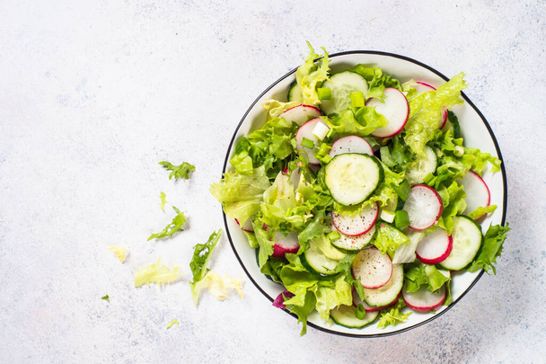 Zöld saláta friss levelekkel, retekkel, uborkával és olívaolajjal. - Fotó, kép