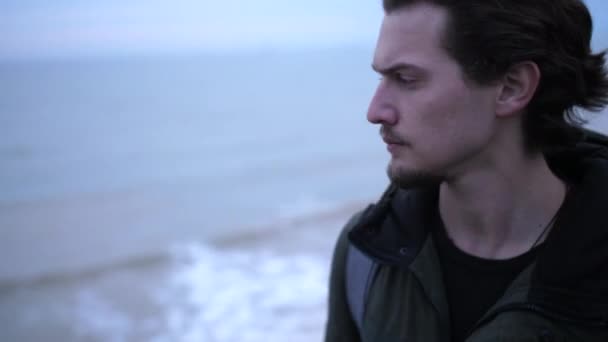 Ritratto di giovane uomo depresso in vacanza sulla spiaggia invernale - Filmati, video