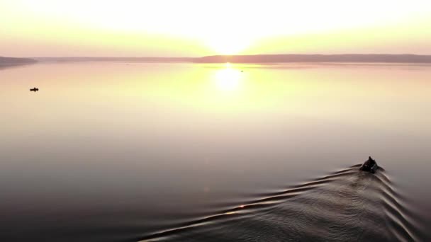 Letecký pohled na lodě s rybáři na obrovském povrchu jezera v paprscích letního zapadajícího slunce. Koncept hobby - Záběry, video