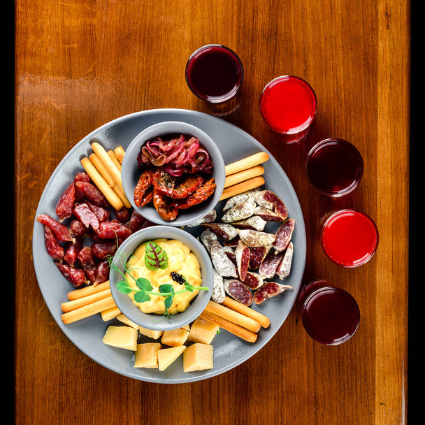 tasting set, assorted alcoholic tinctures and snacks. still-life tinctures on a wooden background - Foto, immagini