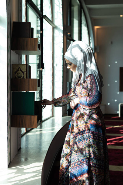 Fiatal hagyományos muszlim nő vesz Korán a mecsetben - Fotó, kép