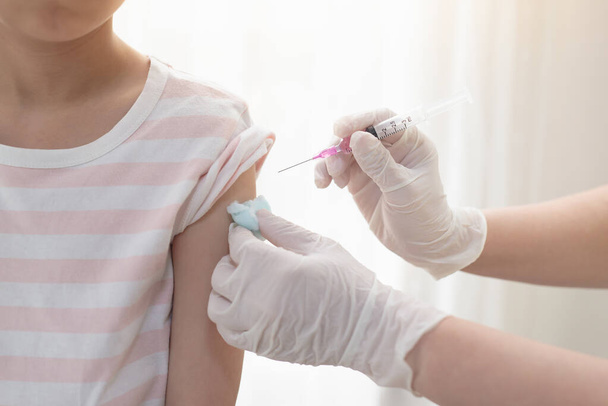 Criança asiática a receber injeção ou vacina.Concept luta contra o vírus covid-19 corona vírus - Foto, Imagem