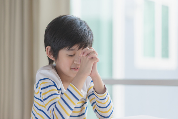 Niedliche asiatische Kind Junge beten mit geschlossenen Augen in den Morgen - Foto, Bild
