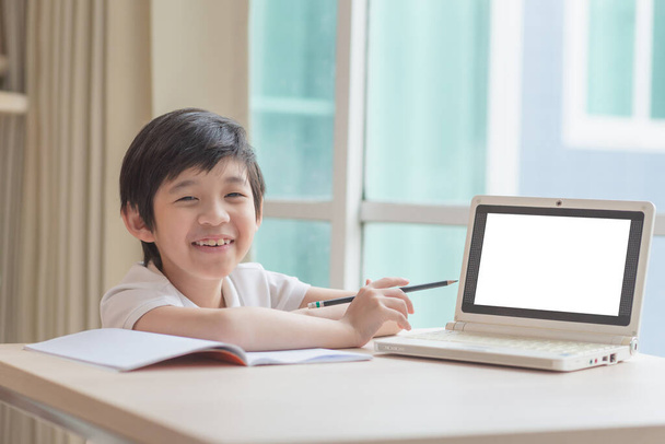 Söpö aasialainen lapsi oppiminen luokan tutkimus verkossa tyhjä näyttö kannettavan kotona. - Valokuva, kuva