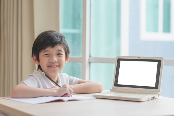 Cute Asian child learning class study online with a blank screen laptop at home .Social distancing  concept - 写真・画像