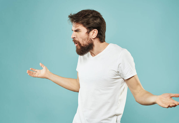 Cute man on a blue background gestures with his hands stress Scream irritability outrage - Foto, Imagem
