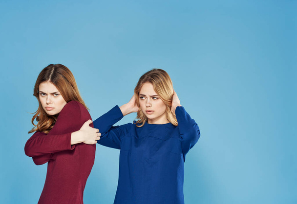 two women in dress conflicts quarrel emotions blue background - Fotó, kép