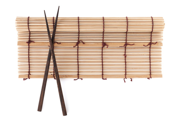 Chopsticks over bamboo mat - Photo, Image