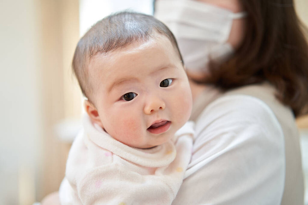 aziatische baby knuffel door mam - Foto, afbeelding