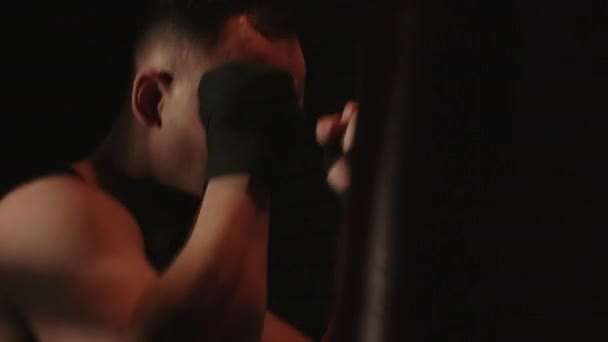Video brunetky muž trénink s boxovací pytel - Záběry, video