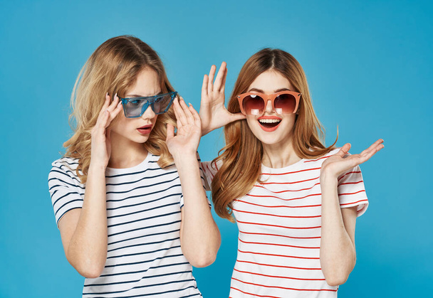 iloinen naiset raidallinen t-paidat yllään aurinkolasit muoti viestinnän studio - Valokuva, kuva