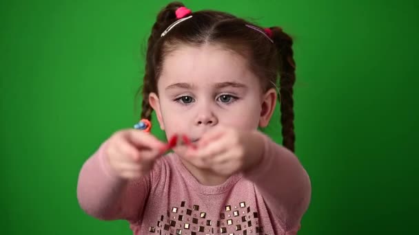 Het kind onderzoekt en demonstreert een gebit plaat om kromme tanden recht te zetten. - Video