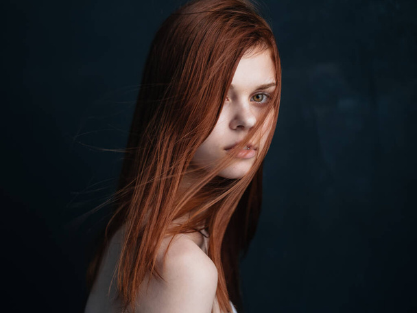 Side view of pretty woman with red hair on a dark background - Foto, immagini