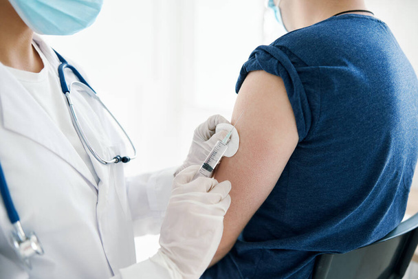 жінка-лікар дає ін'єкцію в плече Пацієнт лабораторія помічник вакцини
 - Фото, зображення