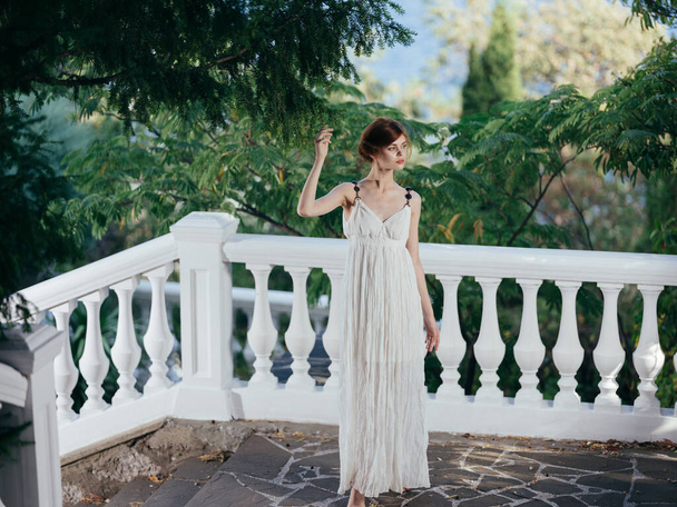 Beautiful woman in white dress traditional greek clothing nature green leaves - Foto, immagini