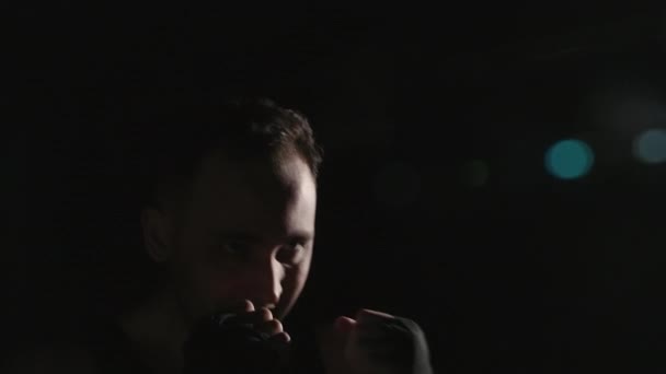 Verfilmung eines Mannes mit Boxbändern auf schwarzem Hintergrund - Filmmaterial, Video