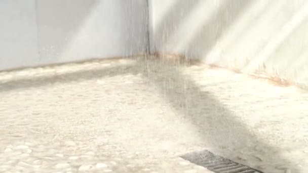 Bodenabfluss, fließendes Wasser in der Dusche. Zeitlupe des Fliesenbodens in einer Dusche mit fließendem Wasser. Bodenablauf aus Edelstahl mit Regenwasser. - Filmmaterial, Video