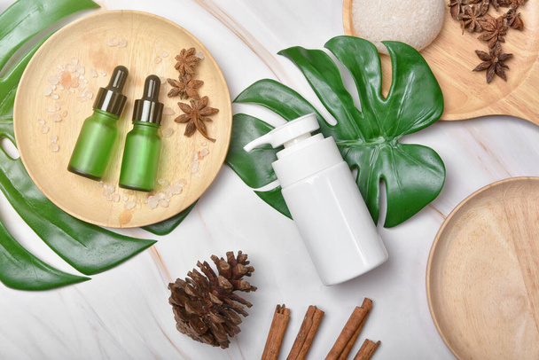 Envases de botellas cosméticas con hojas de hierbas verdes, etiqueta en blanco para maqueta de marca orgánica, concepto de producto de belleza natural para el cuidado de la piel. - Foto, Imagen